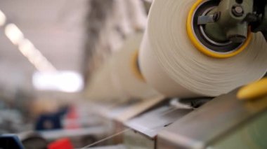 İplik ipliklerinin yakın çekim makaraları. Tekstil fabrikası ekipmanı. Tekstil fabrikası. Dönen yapım. İplik yapma süreci. İplik üretimi. Fabrika makineleri makaraları ya da pamuklu bobinleri geri sarıyor