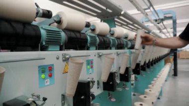 Dönen yapım. İplik yapma süreci. Tekstil fabrikası ekipmanı. İplik üretimi. Tekstil fabrikası. Fabrika makineleri makaraları ya da pamuklu ya da yün ipliklerle bobinleri geri sarıyor. 