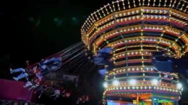 BIELLA, İtalya, 11 Haziran 2022: ışıklı atlı karınca. Tema parkı. Popüler salıncaklar. Renkli bir atlıkarınca. Eğlence parkı. Eğlence Parkı 'nda Popüler Sandalye Dönüşü. Yüksek kalite 4k görüntü