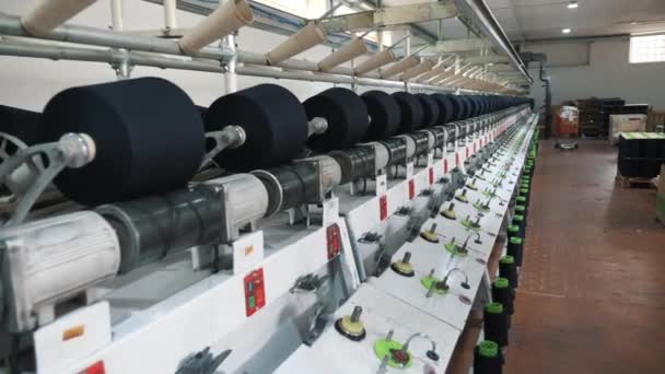 繊維工場だ 糸の製造工程だ 糸の生産 スピニング生産 繊維工場設備 工場機械は リールまたはボビンを綿または毛糸で巻き戻しています — ストック動画