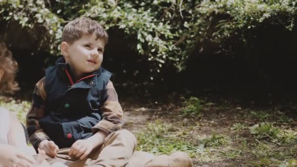 Roztomilý Chlapeček Sedí Trávě Parku Někde Pozorně Dívejte Poslouchejte Venkovní — Stock video