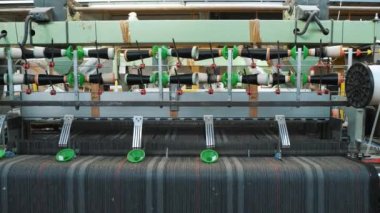 Dokuma makinesi. Yakın plan. Bir tekstil fabrikasında endüstriyel dokuma tezgahı makinesi çalışıyor. Dokuma kumaşı endüstriyel bir makine tarafından serbest bırakılıyor. Dokuma. kumaş üretimi