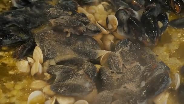 าอาหารทะเล ใกล ทอดหอยและเปล อกด วยกระเท ยมในน นมะกอกในกระทะขนาดใหญ — วีดีโอสต็อก