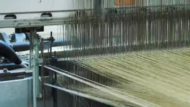 編む機械の設備 クローズアップ 織物工場で作業プロセスの産業織機機械 編まれた生地は産業機械によって解放されます ウィービング ファブリック生産 — ストック動画