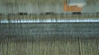 Dokuma makinesi. Yakın plan. Bir tekstil fabrikasında endüstriyel dokuma tezgahı makinesi çalışıyor. Dokuma kumaşı endüstriyel bir makine tarafından serbest bırakılıyor. Dokuma. kumaş üretimi