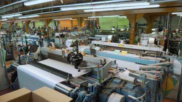 织机的设备 工业编织机在一个纺织厂的工作过程中 一种工业机器正在把织造的织物卸下 织毛衣织物生产厂 — 图库视频影像