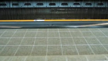 Dokuma tezgahı. Tekstil fabrikası ekipmanı. Yakın plan. Otomatik dokuma makinesi iplik kumaşı üretiyor. Dokuma fabrikası. Tekstil endüstrisi. kumaş üretimi. 