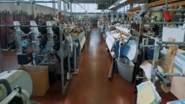 Dokuma fabrikası. Tekstil fabrikası ekipmanı. Atölyede çalışan birçok otomatik dokuma tezgahı var. Bu makineler iplik kumaşı üretiyor. Tekstil endüstrisi. kumaş üretimi. 
