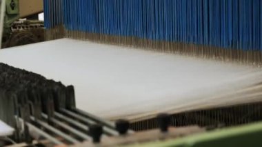 Dokuma tezgahı. Tekstil fabrikası ekipmanı. Yakın plan. Otomatik dokuma makinesi iplik kumaşı üretiyor. Dokuma fabrikası. Tekstil endüstrisi. kumaş üretimi. 