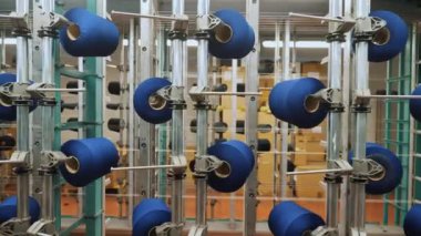 İplik makaraları. Endüstriyel tekstil fabrikasının atölyesi. Bir sürü iplik makarası olan raflar. Daha fazla kumaş üretimi için ipliklerin boyanıp kurutulması. Dokuma fabrikası. Tekstil endüstrisi. Dokuma tezgahları