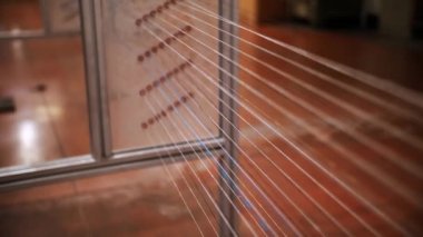 İplik. Yakın plan. Tekstil kumaşları örmek için endüstriyel örgü makinesinin kumaş üretimi için ipliklerin boyanıp kurutulması. Tekstil endüstrisi. Kumaş üretimi. Dokuma fabrikası. 