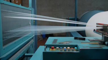 Dokuma fabrikası. İplik boyası. Tekstil endüstrisi. Renklendirme için iplikleri hazırlama, istenen rengin kumaşlarının daha fazla üretimi için otomatik çalışma süreci. Tekstil fabrikası ekipmanları