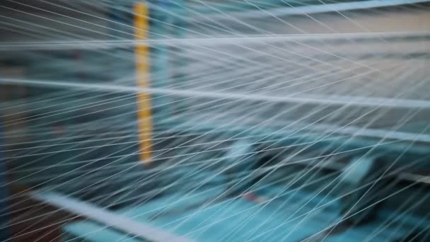 スレッド クローズアップ ライトの伸ばされた糸から作られた抽象的な図面 織物の編み物のための産業編み機械によるさらなる生地の生産のための糸の染料そして乾燥 — ストック動画