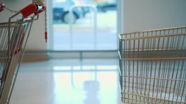 Boş alışveriş arabaları. Süpermarket. Yakın plan. Biri boş bir alışveriş arabasını bir süpermarkete yerleştiriyor.