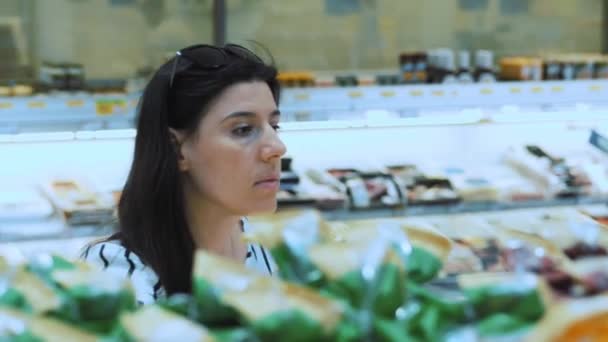 Een Vrouw Kiest Boodschappen Een Supermarkt Portret Een Brunette Onderzoekt — Stockvideo