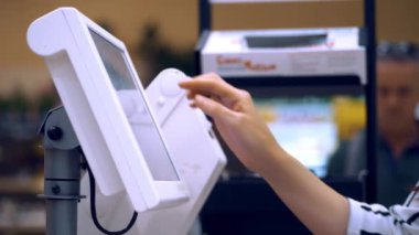 Kendi kendine hizmet terazileri. Yakın plan. Bir süpermarketin bakkal bölümündeki elektronik self-servis terazilerindeki yiyecekleri tartmak. Belirtilen ağırlığa ve sebze ve meyve fiyatına sahip etiket