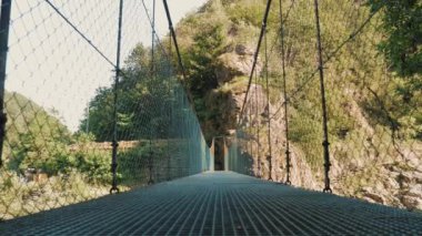 Asma köprü. Ulusal parktaki hızlı dağ nehri üzerindeki uzun ve boş asma köprü. seyahat ve macera. İtalya. yaz günü. 