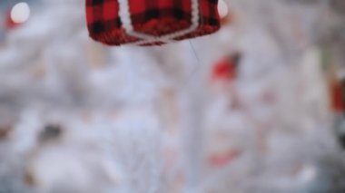 Noel ağacı oyuncağı. Yakın plan. Mağazadaki beyaz bir yapay Noel ağacına küçük bir hediye şeklinde Noel süsü. Fuar, süpermarket ya da alışveriş merkezinde Noel aksesuarları. Ruh