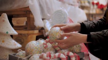 Noel süsleri, aksesuarlar. Alışveriş. Yakın plan. Elele tutuşan bir kadın Noel süsleri. Kış tatilleri için bir mağazada, adil, süpermarkette ya da