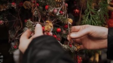 Noel süsleri, aksesuarlar. Alışveriş. Yakın plan. Elele tutuşan bir kadın Noel süsleri. Kış tatilleri için bir mağazada, adil, süpermarkette ya da