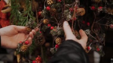 Noel süsleri, aksesuarlar. Alışveriş. Yakın plan. Elele tutuşan bir kadın Noel süsleri. Kış tatilleri için bir mağazada, adil, süpermarkette ya da