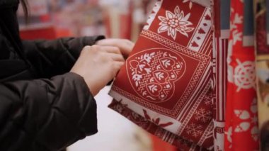 Noel süsleri, aksesuarlar. Alışveriş. Yakın plan. Kadın Noel 'e kadar bir mağaza, mağaza, fuar, süpermarket veya alışveriş merkezinde Noel masası için şenlikli bir masa örtüsü seçer.