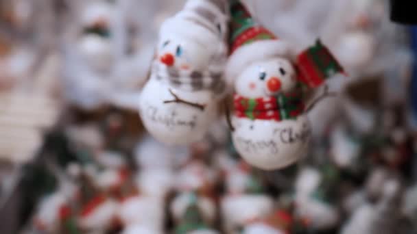 圣诞装饰品 圣诞树玩具 圣诞装饰 玩具形状滑稽的雪人 模糊的背景 圣诞博览会 超级市场或购物中心 — 图库视频影像