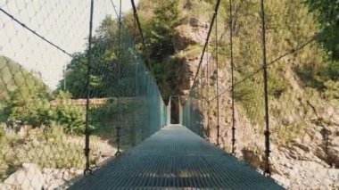 Asma köprü. Ulusal parktaki hızlı dağ nehri üzerindeki uzun ve boş asma köprü. seyahat ve macera. İtalya. yaz günü. 