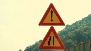 Trafik levhası, sembol ilgisi, yol darlığı. Yol çalışması. Araç için yol kenarı tabelası. Yakın plan. Tamir çalışmaları yolda devam ediyor. Bürokrasiyle kapatılmış..