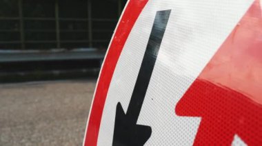  Yol çalışması tabelası. Yol tamiri. Yakın plan. Kırmızı ve siyah oklar yuvarlak kırmızı çerçeve işaretinde. Ters hareket. Tamir çalışmaları yolda devam ediyor. Yol işareti. 