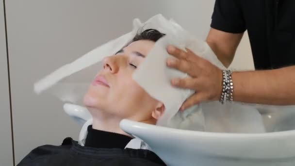 Der Friseur Trocknet Die Brünetten Mädchen Salon Mit Einem Handtuch — Stockvideo