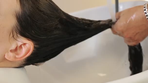 Kadeřník Umývá Ženské Vlasy Před Barvením Stylista Sprchuje Vlasy Brunetek — Stock video
