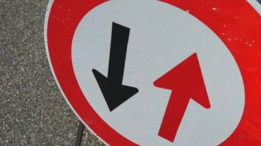  Yol çalışması tabelası. Yol tamiri. Yakın plan. Kırmızı ve siyah oklar yuvarlak kırmızı çerçeve işaretinde. Ters hareket. Tamir çalışmaları yolda devam ediyor. Yol işareti. 