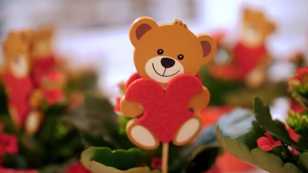 バレンタインデー クローズアップ バレンタインデーの贈り物として花のポットで装飾的なテディベアのおもちゃ お祝いの装飾 バレンタインデーの装飾 ラブコンセプト — ストック動画