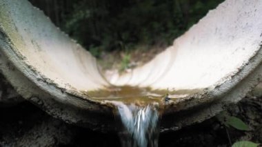 Orman drenaj sistemi. Su kanaldan akıyor. Bir turist ormandan geçip Alplerdeki kanalizasyona gidiyor. Yağış koruması için drenaj sistemi. Çevresel koruma