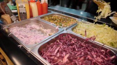 Şef aşağıdaki malzemeleri kullanarak shawarma hazırlıyor: lahanalı et soslu sebzeler salatalık soğanı baharatlı lahana, baharatlı biber, patates yeşili, havuç. Yüksek kalite 4k görüntü