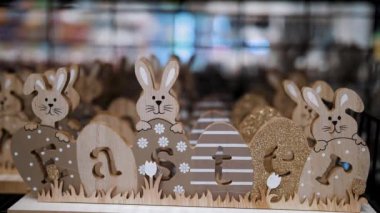 Paskalya indirimi. Paskalya süslemeleri ve dükkandaki ev için hediyeler. Geleneksel Paskalya tavşanları ve yumurtalarıyla tahta, kontraplaktan oyulmuş dekoratif Paskalya Paskalya,