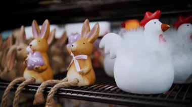 Paskalya panayırı. Yakın plan. Paskalya tavşanlarının, tavukların ya da piliçlerin çok renkli heykelcikleri bir mağazada sergileniyor. Geleneksel Avrupa paskalya dekoru ve dekorasyonları. 