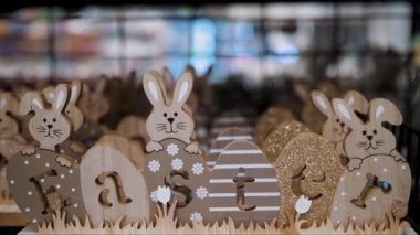 Paskalya indirimi. Paskalya süslemeleri ve dükkandaki ev için hediyeler. Geleneksel Paskalya tavşanları ve yumurtalarıyla tahta, kontraplaktan oyulmuş dekoratif Paskalya Paskalya,