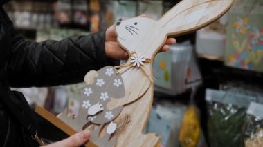 Paskalya panayırı. Yakın plan. Paskalya süslerini tutan kadın elleri. Paskalya tavşanının komik biblosu. Katolik Paskalyası için geleneksel Avrupa dekorasyonu