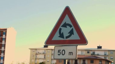 Yuvarlak tabela ve plaka 50 metre gösteriyor. Bu da önümüzde bir kavşak olduğunu gösteriyor. Yol boyunca şehirde yol işaretleri var. Yüksek kalite 4k görüntü