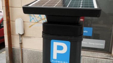 Akan Kuş 'tan güneş enerjisiyle çalışan bir parkmetreye yakın plan üzerinde şehir yaşamı unsurları, çevre dostu kentsel ulaşım çözümleri
