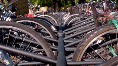 Çevre dostu ulaşım seçeneği olarak kentsel bisikletçiliğin popülaritesi, açık bir park alanında sıralanmış sayısız bisiklet tekerleği ve sepetlerden oluşan yakın çekim.