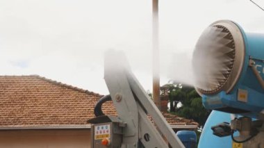 Kamyona monte edilmiş bir su topu, toz kontrolü için güneşli yerleşim yerlerine güçlü bir su akıntısı yayar.