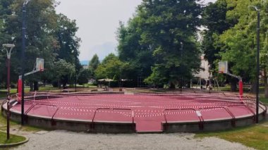 Kırmızı ve Beyaz Bariyer Çaprazlama. Basketbol sahası çevrili bir halk parkı. Yüksek kalite 4k görüntü