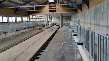Bir mandıra çiftliğinin inşaatı ve onarımı. Demiryolu rayları ve pasif makinelerin yer aldığı geniş çaplı fabrika iç mimarisi, sanayi mimarisi ve tasarımı büyük, pencere kenarlı bir bina içinde sergileniyor