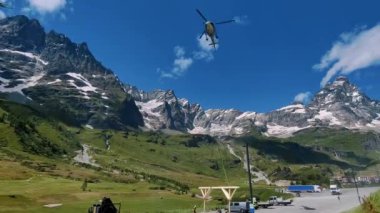 Açık bir günde dağlık arazide bir helikopter. Çevre, vahşi doğa ve kurtarma operasyonları için ideal. Helikopter, yükseklerde malzeme taşımaya yardımcı olur.