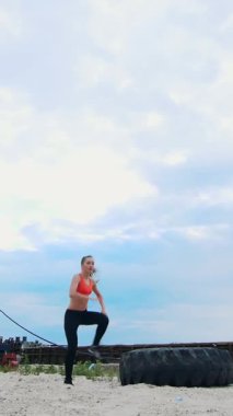 Formda, atletik giyinmiş bir kadın dramatik bulutlu bir gökyüzünün altında enerjik bir şekilde çatıda egzersiz yapıyor. Onun dinamik hareketi gücü ve kararlılığı yansıtıyor, ilham verici ve güç verici bir sahne yaratıyor..