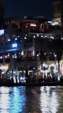 DUBAI, BİRLİK ARAB EMIRATES, BAE - 10 Mayıs 2017: Hotel Jumeirah Al Qasr Madinat, su kanalı boyunca gece yürüyüşü, bir tekne. Fenerler binaları aydınlatıyor..