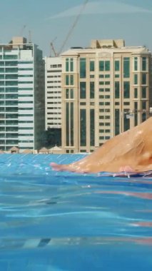 güzel kadın bacaklar, ayak, şehrin gökdelenlerin fonunda güzel şehir manzaralı çatı üst havuzda close-up. Mavi su kadın ayakları..